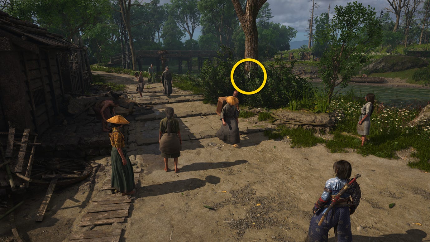 A close-up of a tree by a road in Osaka in Assassin's Creed Shadows, with a yellow circle highlighting the location of a white Origami Butterfly.