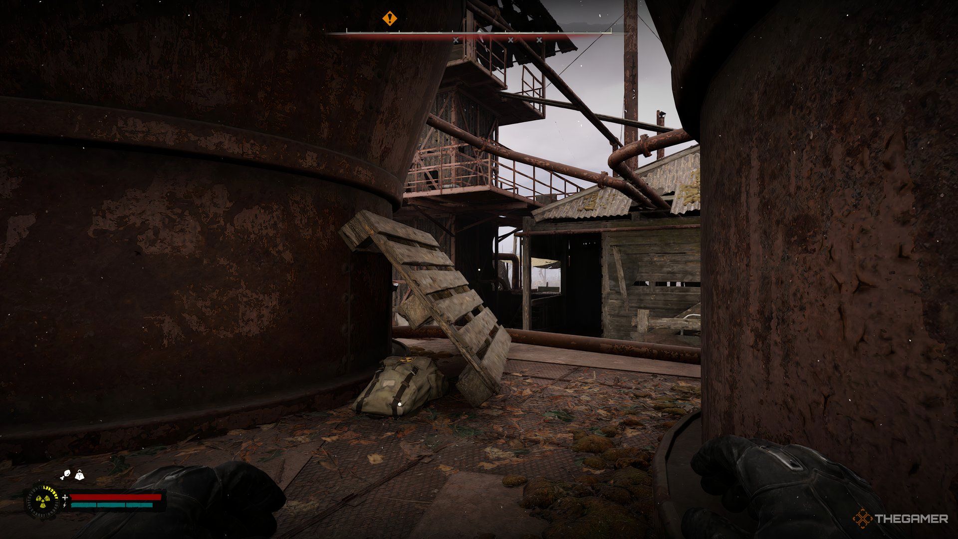 An image showing a stash kept in between rusted oil tanks.