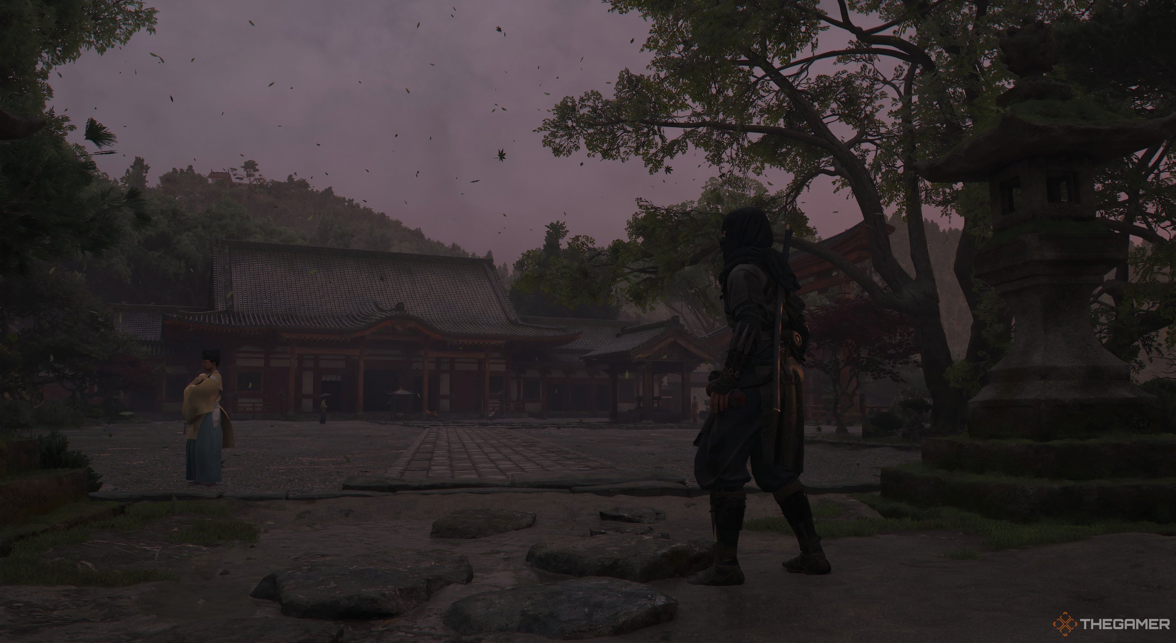 Assassin's Creed Shadows Naoe with a temples in the background. There is a villager in the background looking away from Naoe. Leaves are in the air moving. 