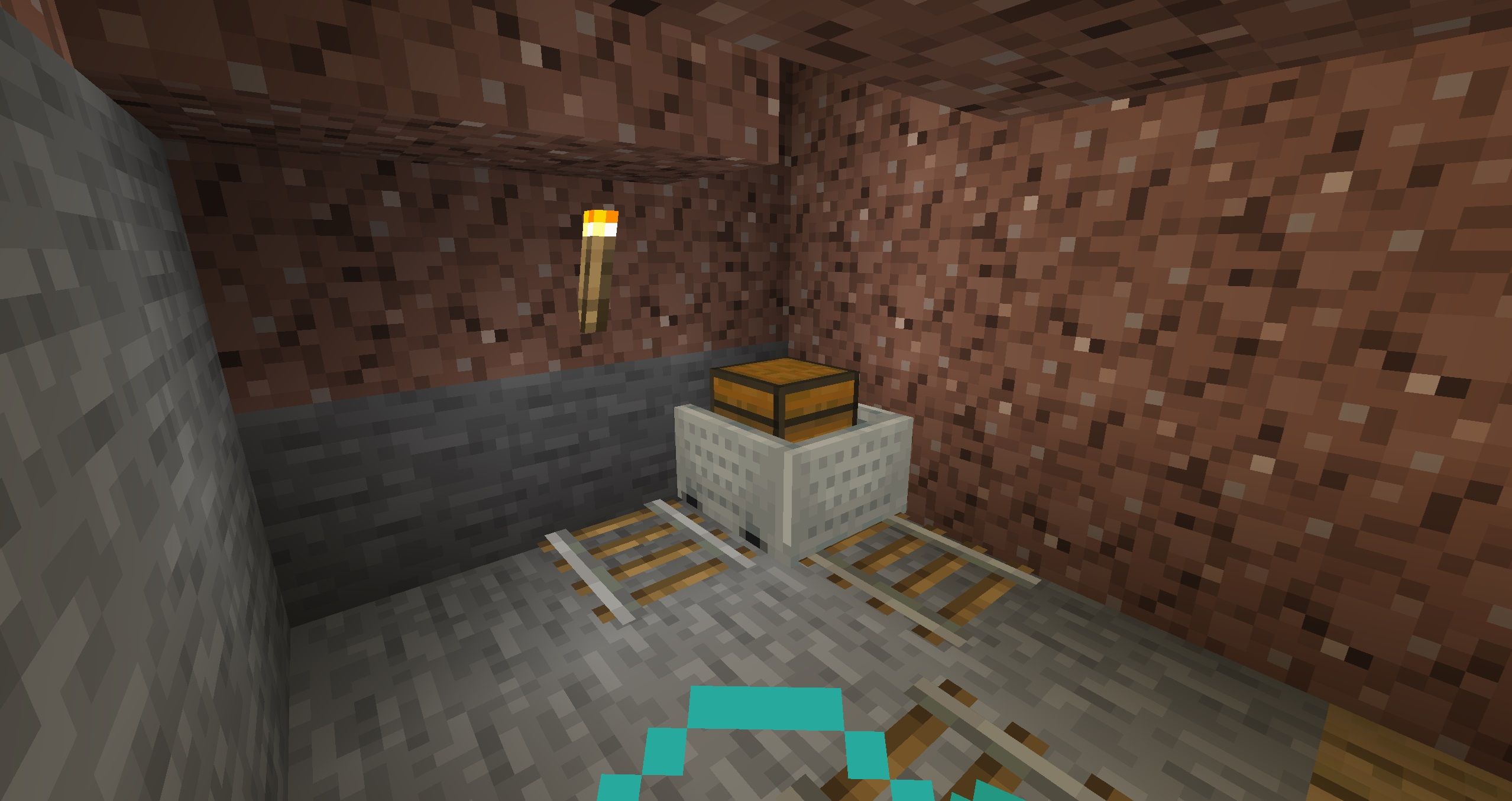 A chest minecart in a granite tunnel lit by a single torch in Minecraft.