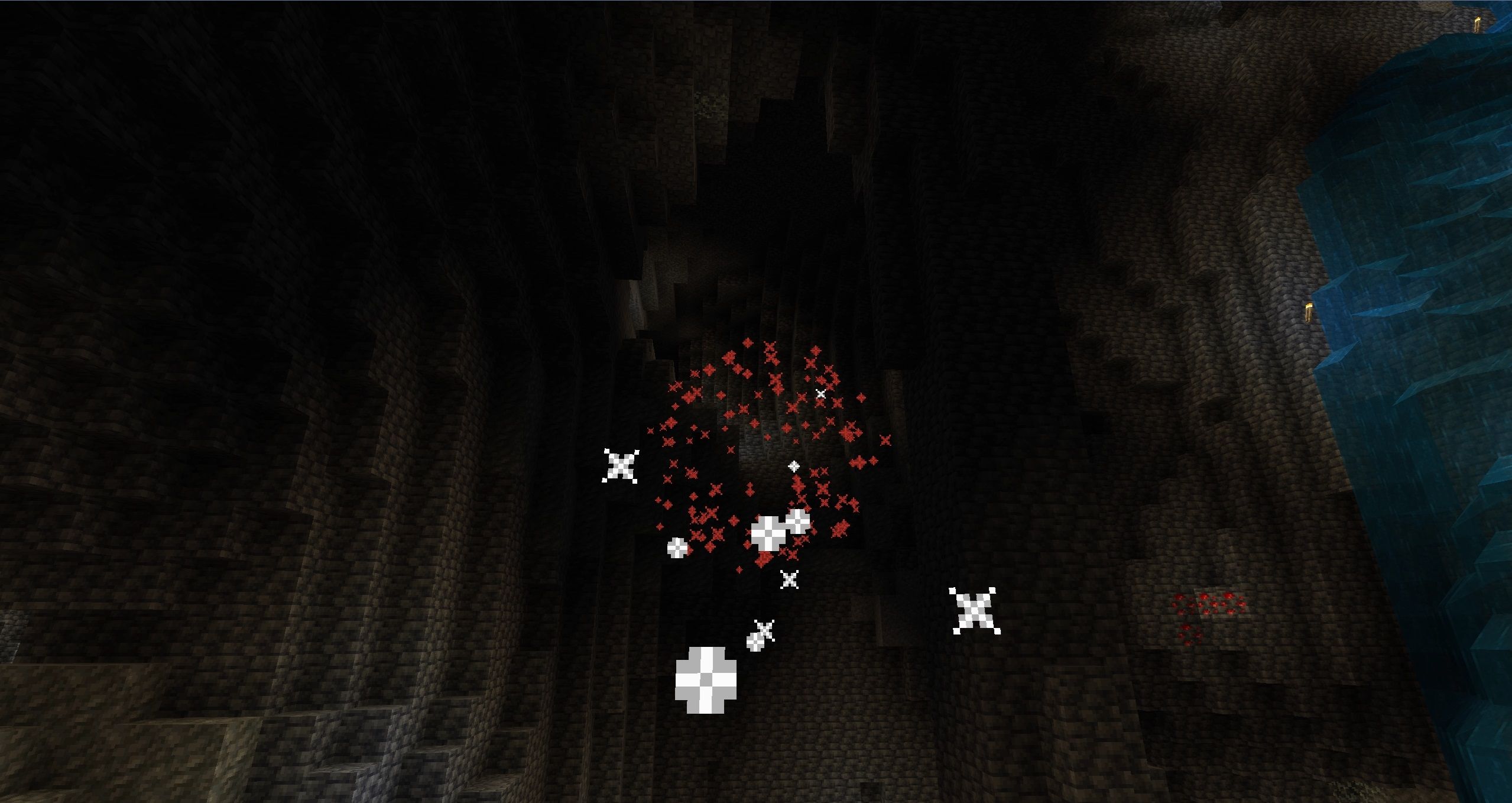 A trail of white particles leading to a red explosion in a big, dark cave in Minecraft.