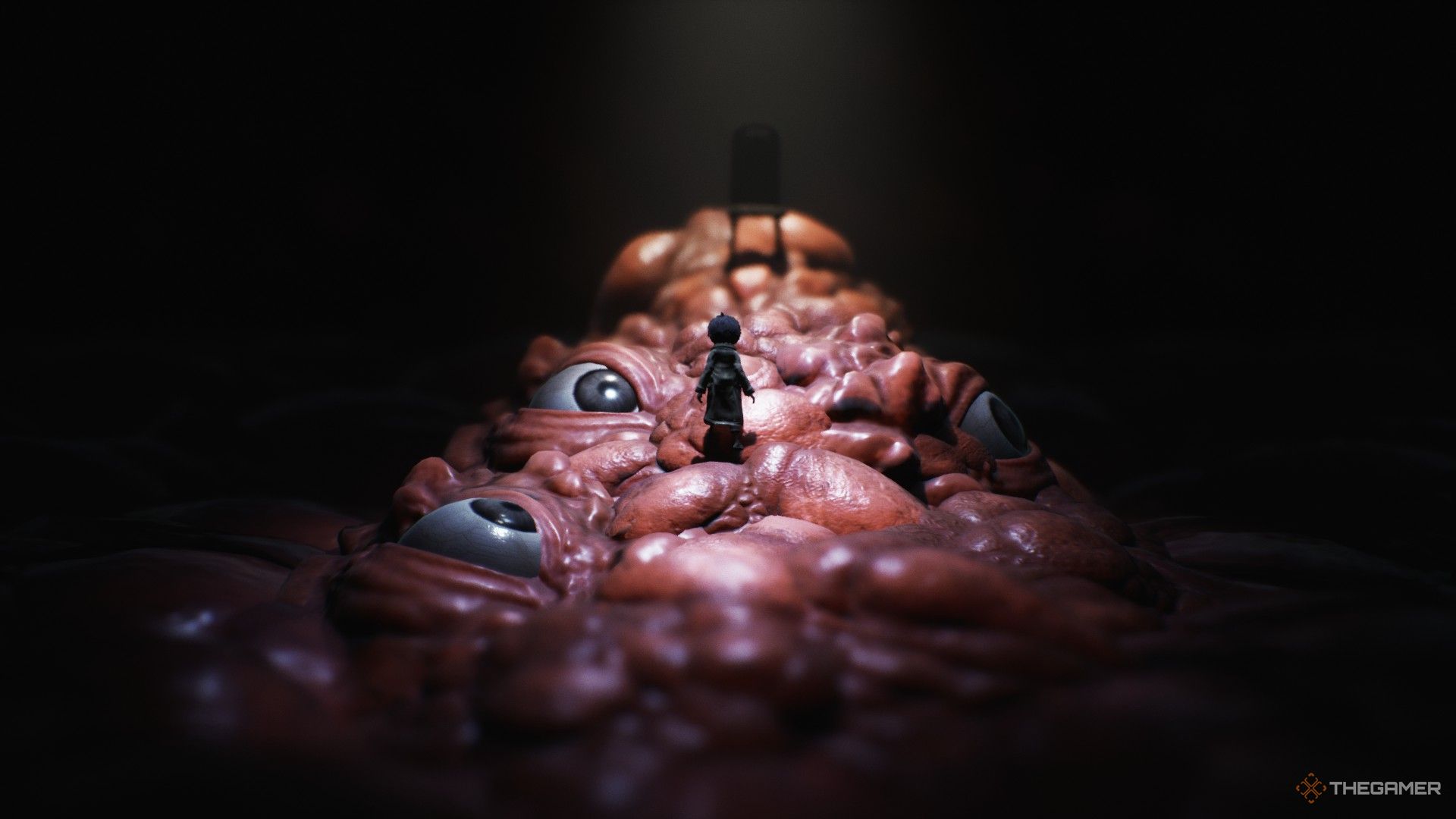 Creepy eyes with the main character as he stands in Little Nightmares 2.