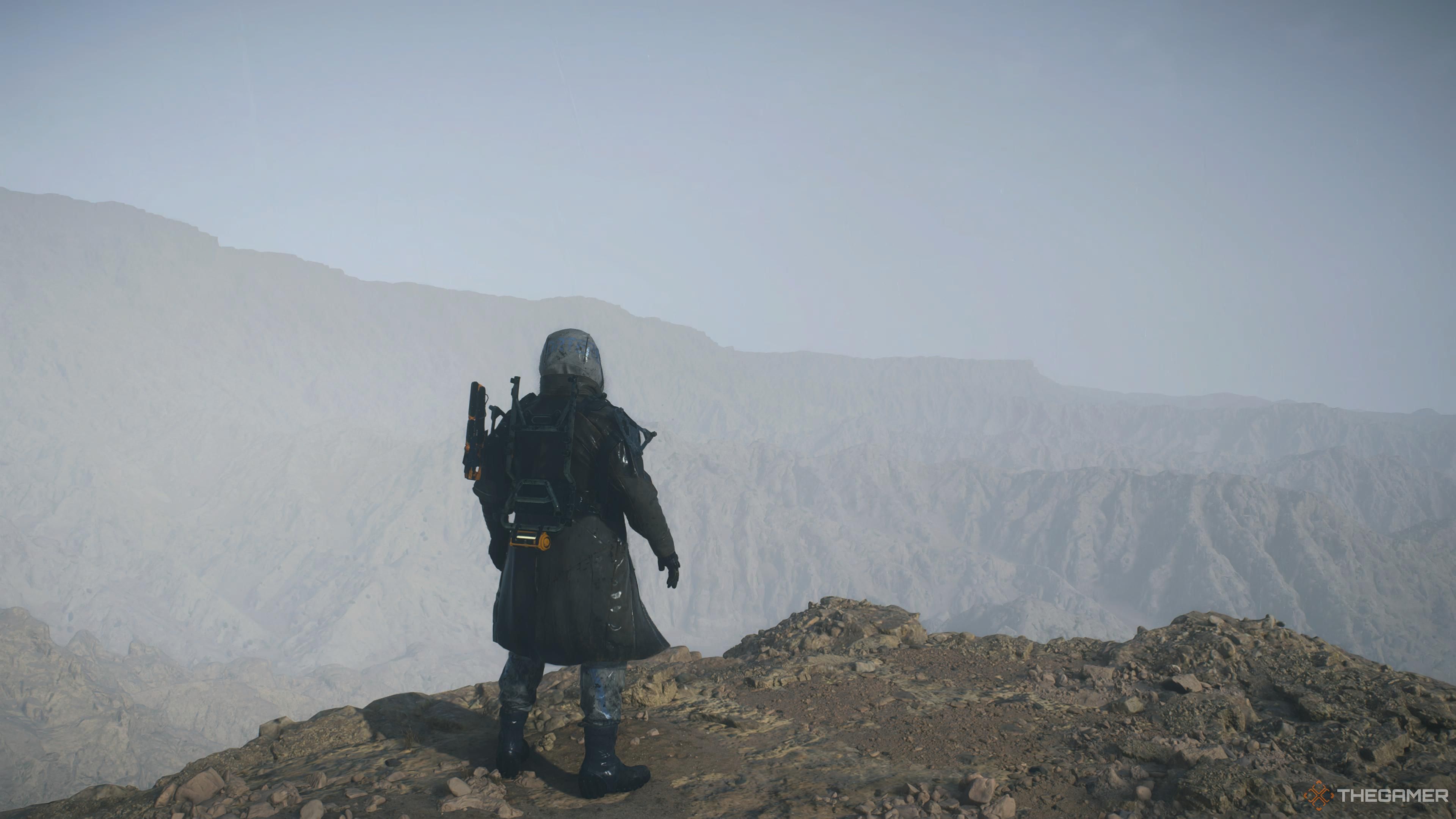 Sam standing still next to a cliff in Death Stranding 2.