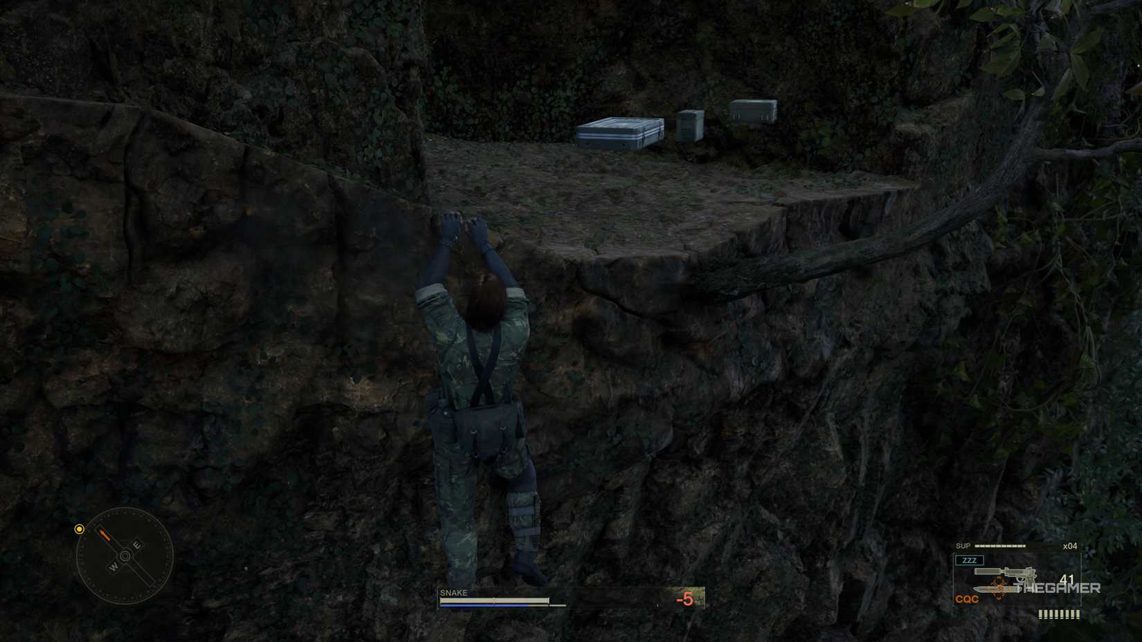 Naked Snake climbing across the cliffside to an alcove where a hidden XM16E1 Assault Rifle and ammunition is in Metal Gear Solid Delta: Snake Eater.