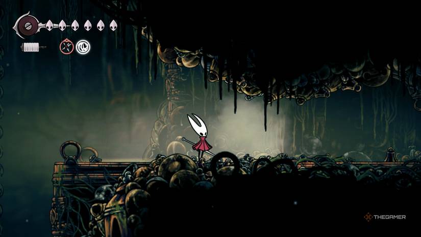 Hornet destroys a false wall and reveals a hidden path to Bellhart in Hollow Knight: Silksong.