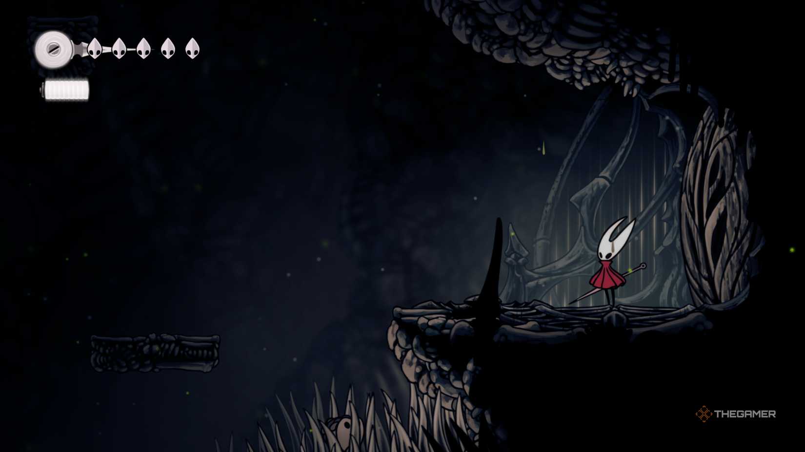 Hornet next to a closed door, looking to a platform on the left, in Hollow Knight: Silksong.