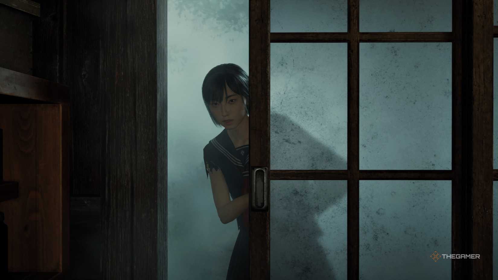 A close shot of the protagonist opening a door in Silent Hill f.