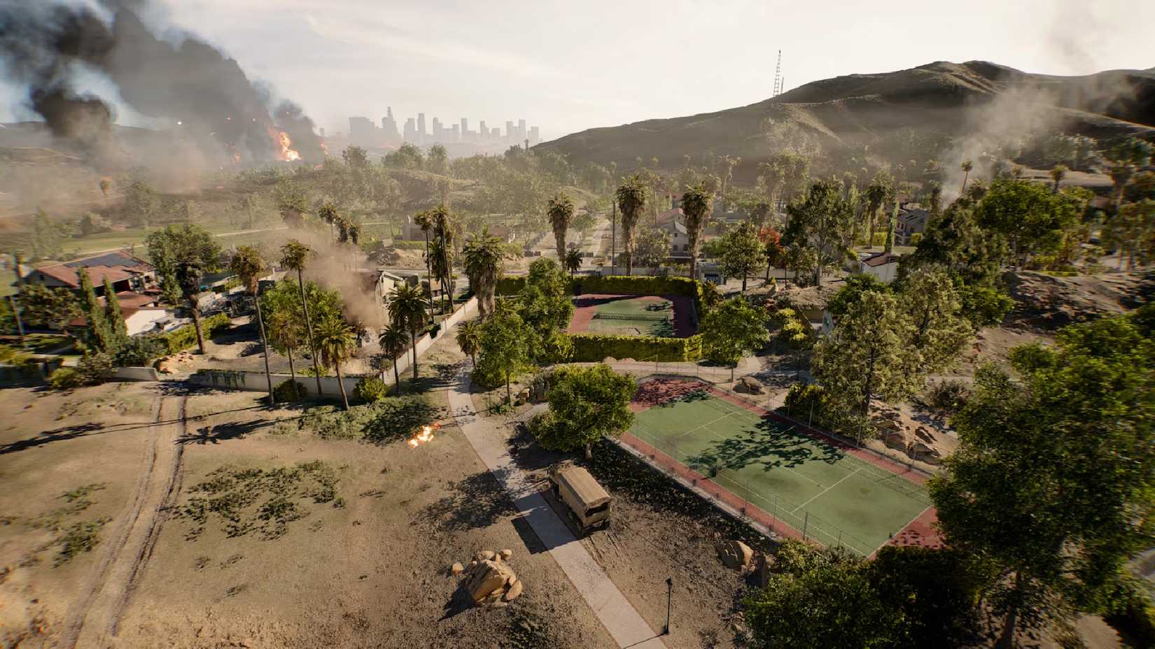 Battlefield 6 California houses in the desert on fire, with the skyline in the background.