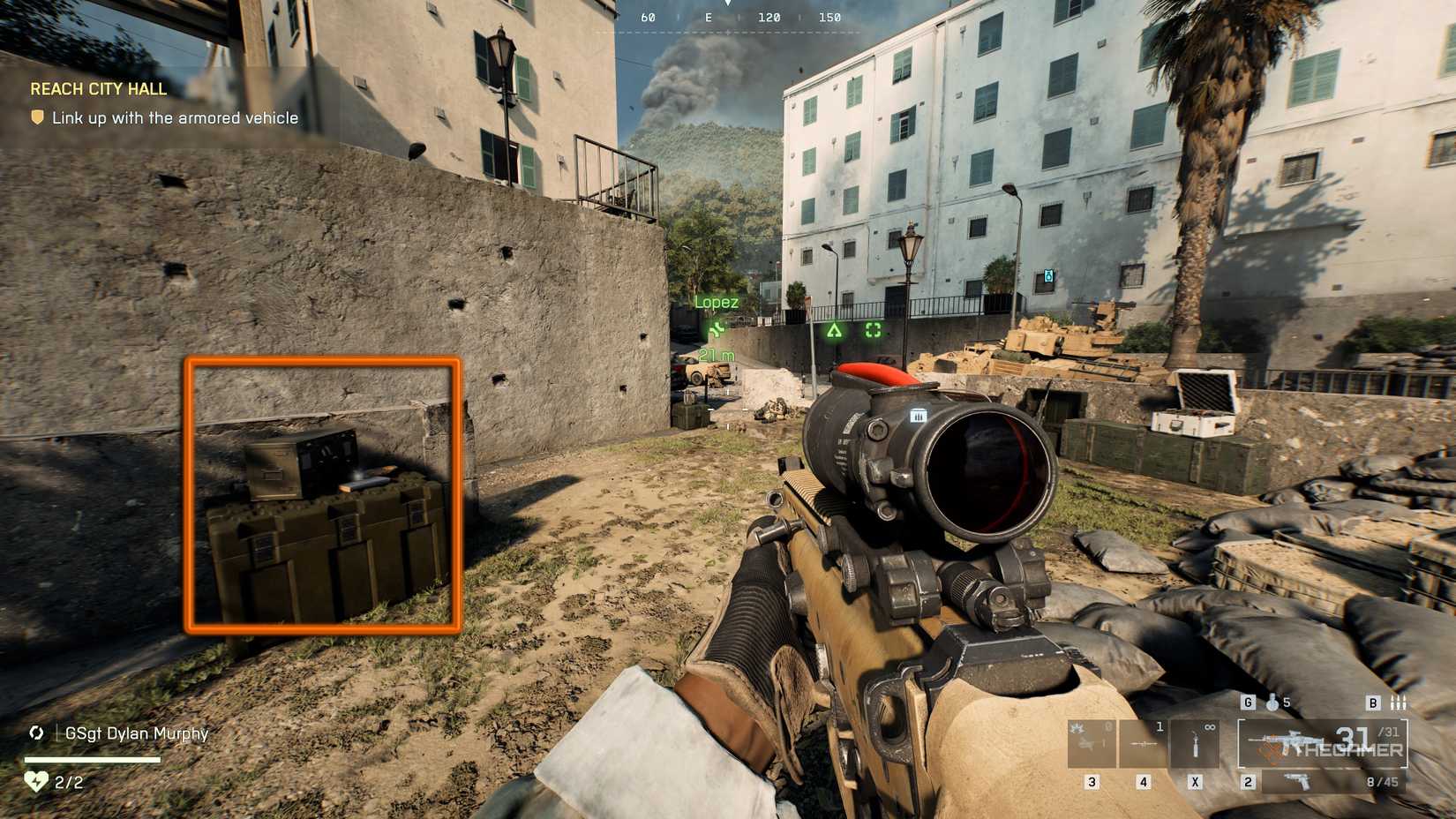 Battlefield 6 player exiting a car park into city streets, with a military crate to the left highlighted by an orange square.