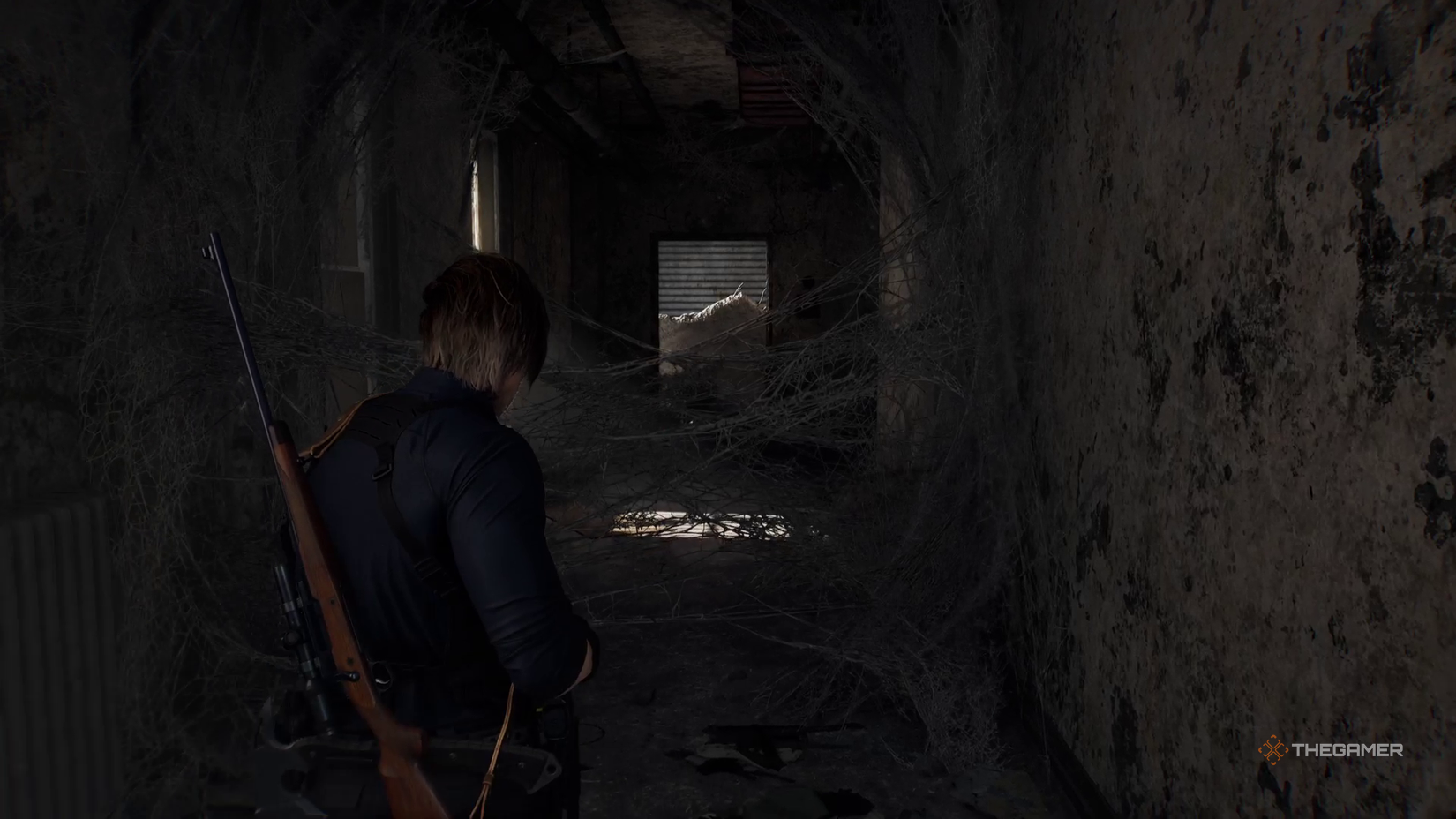 Леон Кеннеди идет по коридору, затянутому паутиной.